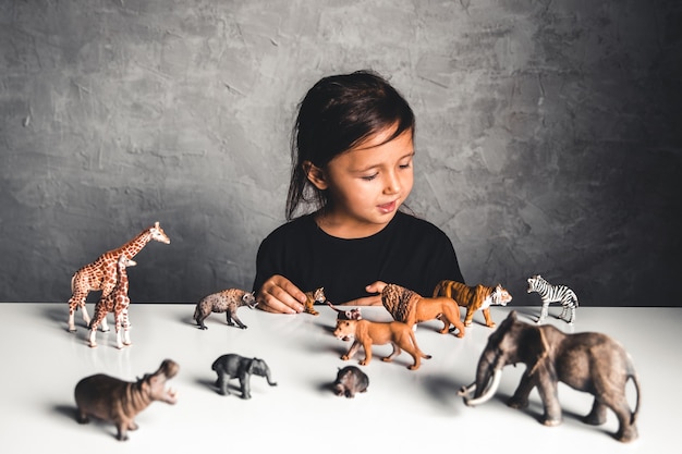 Niña jugando con juguetes de animales en la sala de juegos