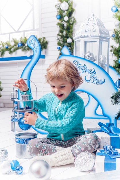 Niña jugando con juguetes navideños