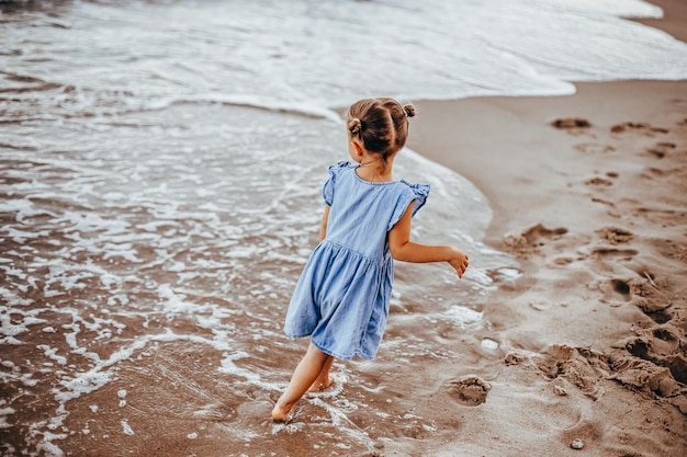 niña jugando junto al mar