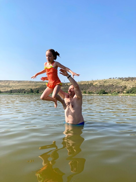 niña jugando en el lago con pompas de jabón