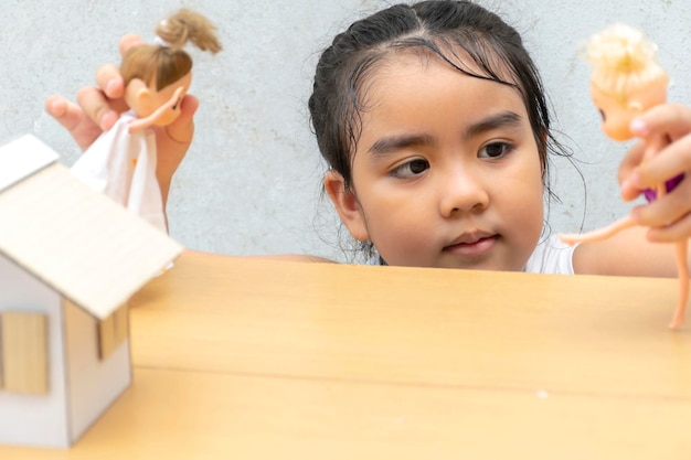 Niña jugando a la muñeca Es un juguete muy valioso para ella Dos muñecas en ambas manos Y hay casas de muñecas que se inventan