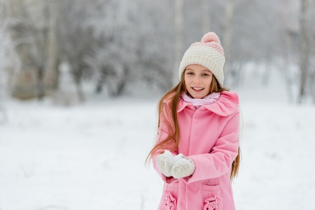 Niña jugando con nieve en vacaciones