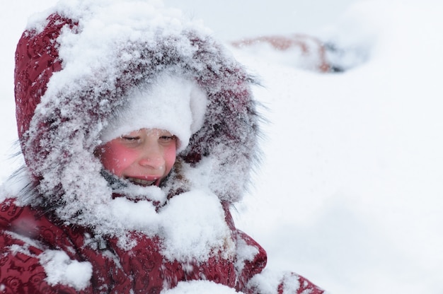 Niña jugando con nieve.