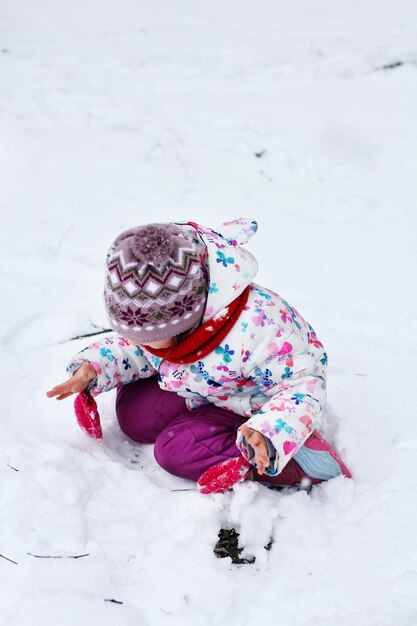 Foto una niña está jugando en la nieve.