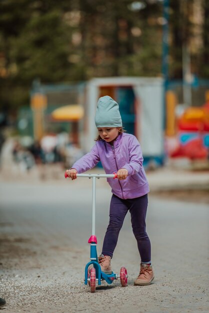 Una niña jugando en el parque. El concepto de socialización familiar en el parque. Una niña se balancea en un columpio, juega juegos creativos.