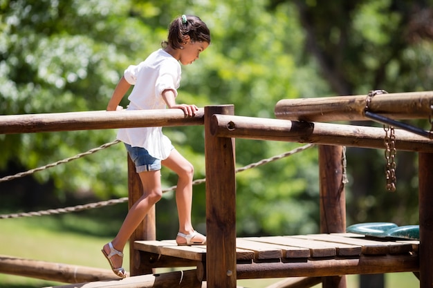 Niña jugando en un paseo en el parque infantil en el parque