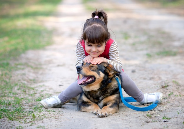 Niña jugando con un perro al aire libre