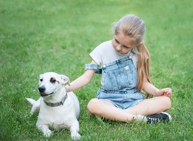 Niña jugando con un perro de raza Jack Russell Terrier