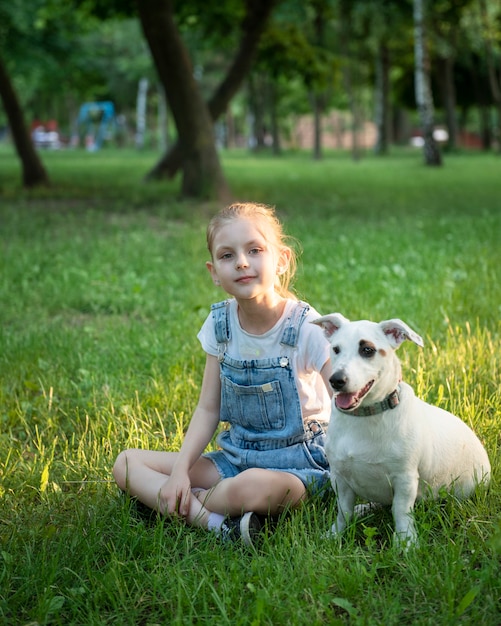 Niña jugando con un perro de raza Jack Russell Terrier