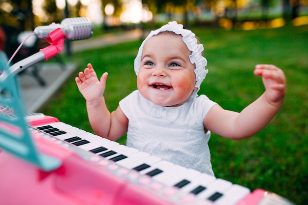 Niña jugando en un piano de juguete en el parque