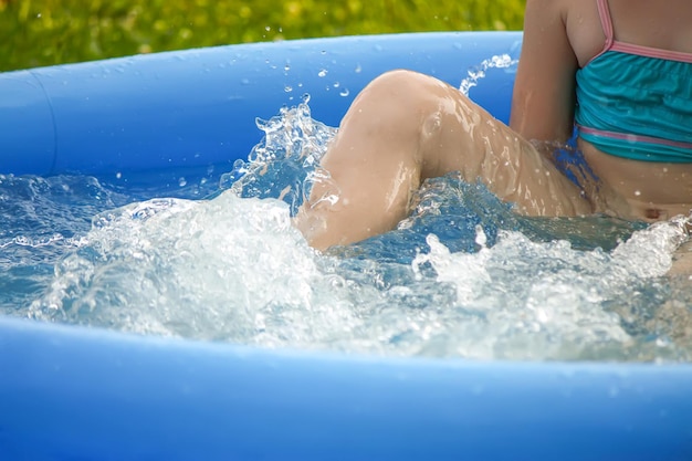 Niña jugando en la piscina al aire libre en verano