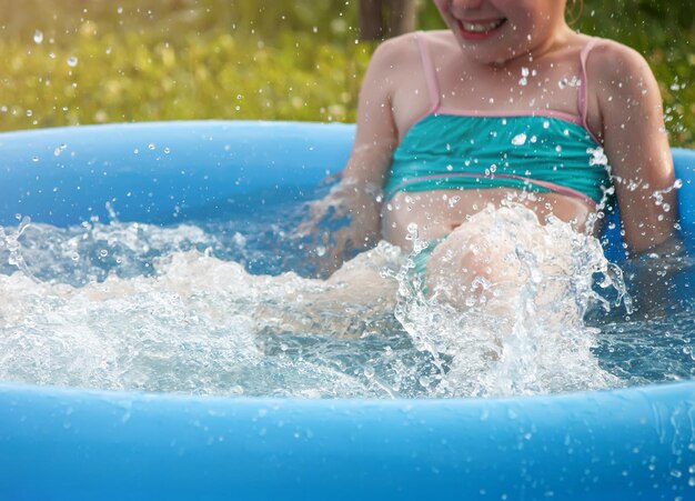 Niña jugando en la piscina al aire libre en verano