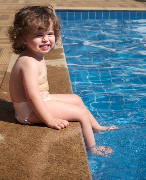 Niña jugando en la piscina en un día soleado