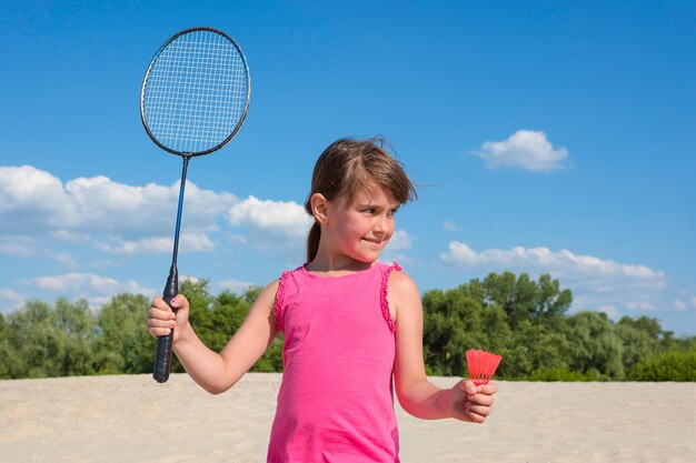Niña jugando playa bádminton familia deportes al aire libre juegos activo estilo de vida saludable concepto