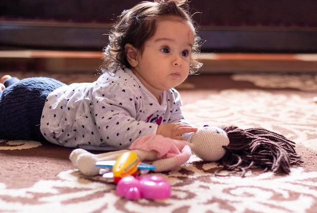 Una niña jugando en el suelo con un juguete.