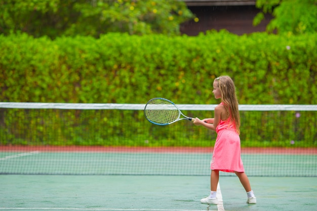 Niña jugando tenis en la cancha