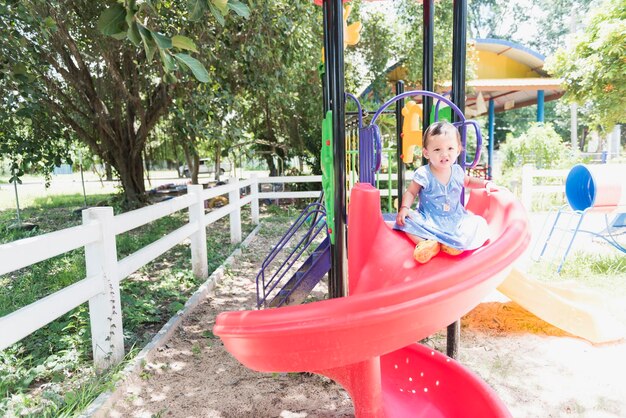 Foto niña jugando en el tobogán en el patio de recreo