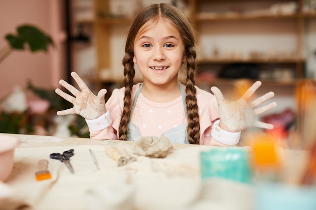 Niña juguetona en clase de cerámica