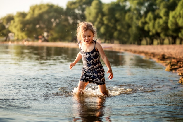 niña junto al río en verano salpica agua