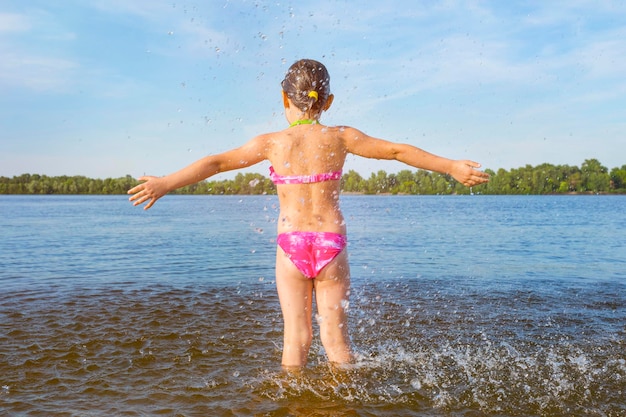 Niña junto al río la vista desde atrás infancia feliz