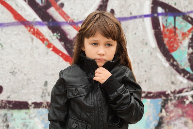 Niña junto a la pared de graffiti