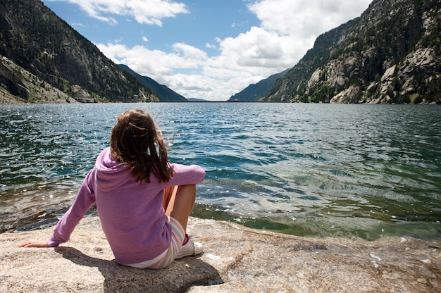 Niña en un lago de montaña