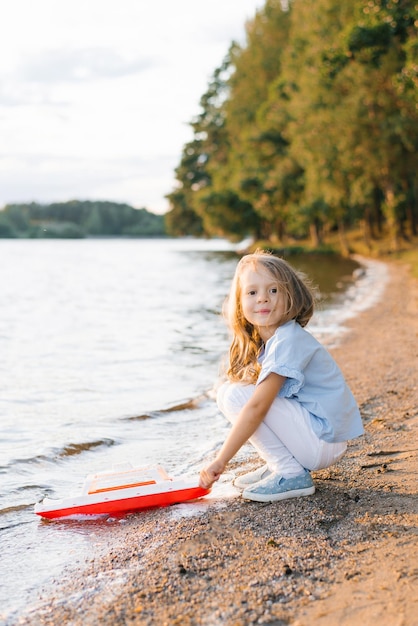 Una niña lanza un bote al lago.