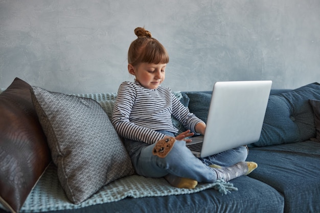 niña con laptop en casa