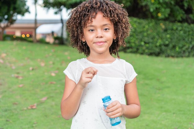 Niña latina jugando con burbujas