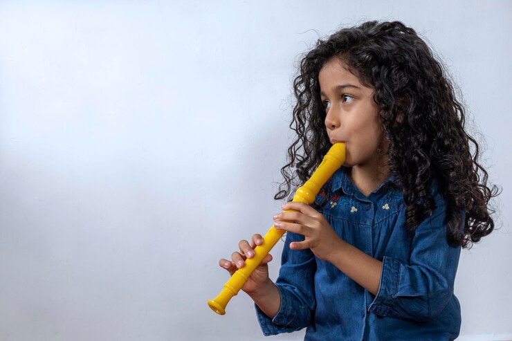 Niña latinoamericana tocando con destreza la flauta soprano
