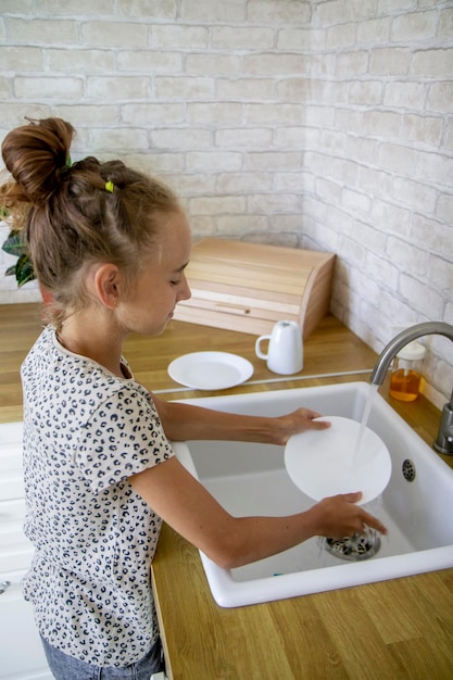 Foto niña lavando platos