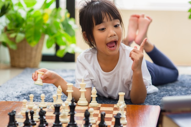 Niña con lección de ajedrez en línea, e-educación, aprendizaje a distancia