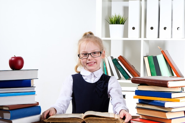 Niña lee libros en la mesa