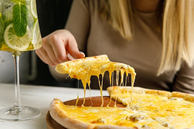 niña levanta pizza sobre la mesa El queso se estira
