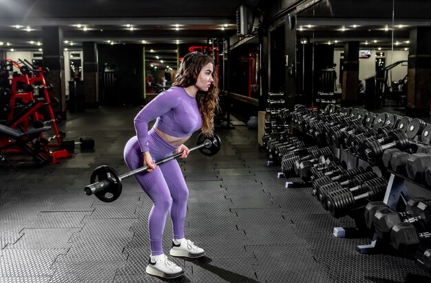 Niña levantando pesas en el gimnasio. concepto de estilo de vida saludable