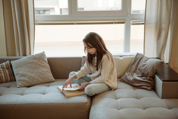 Foto niña leyendo en casa mientras está en cuarentena