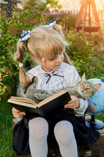 Niña leyendo un libro con un gato