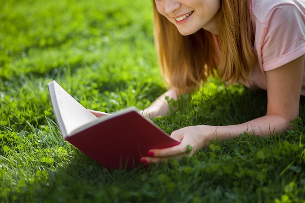 Niña leyendo un libro en el parque. de cerca