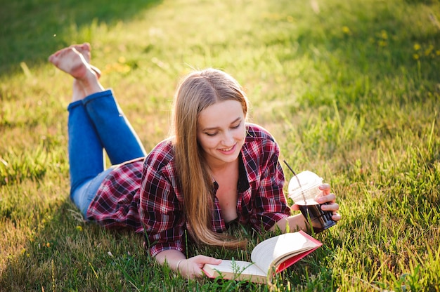 Niña leyendo un libro en un parque de verano