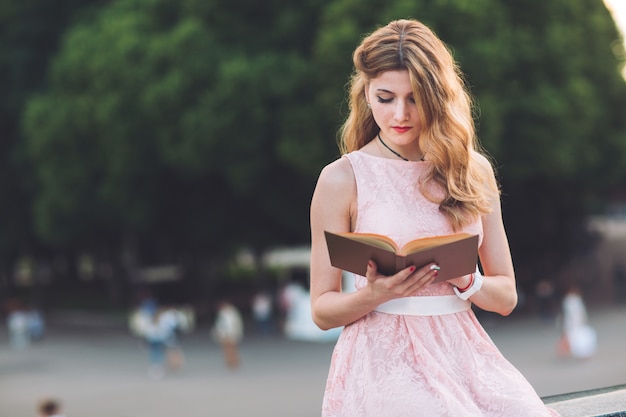 Niña leyendo un libro en el parque.