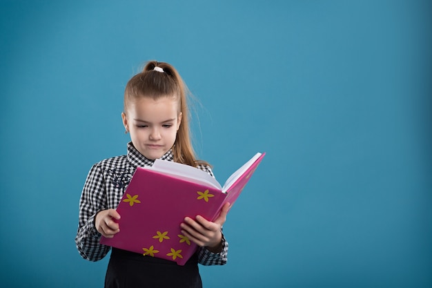 Niña leyendo un libro en una portada rosa