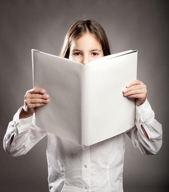 niña leyendo un libro con tapa en blanco