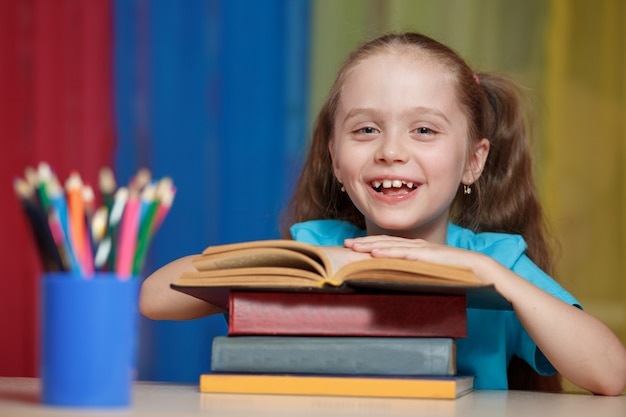 Niña y libro abierto sobre la mesa.