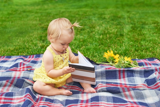 niña con un libro en el parque