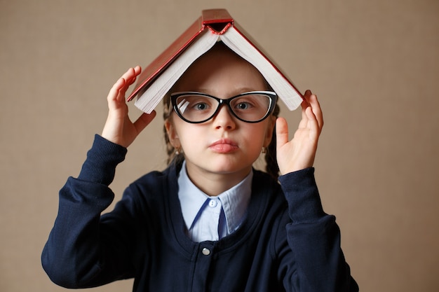 Niña con un libro sobre su cabeza