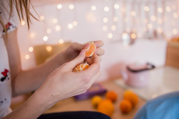 Una niña limpia mandarina con las manos.