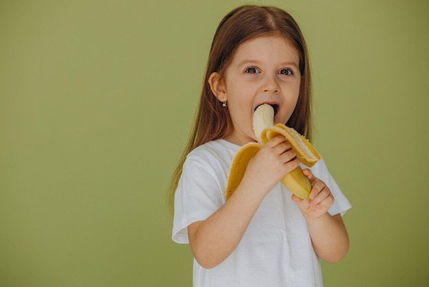 Niña linda aislada con plátano