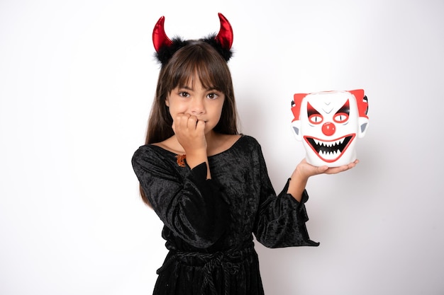 Foto niña linda y aterradora disfrazada de halloween sobre fondo blanco