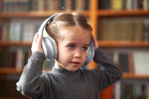 Niña linda con auriculares escucha música