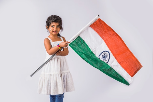 Foto niña linda con la bandera tricolor nacional de la india, aislado sobre fondo blanco. adecuado para el concepto del día de la independencia o el día de la república